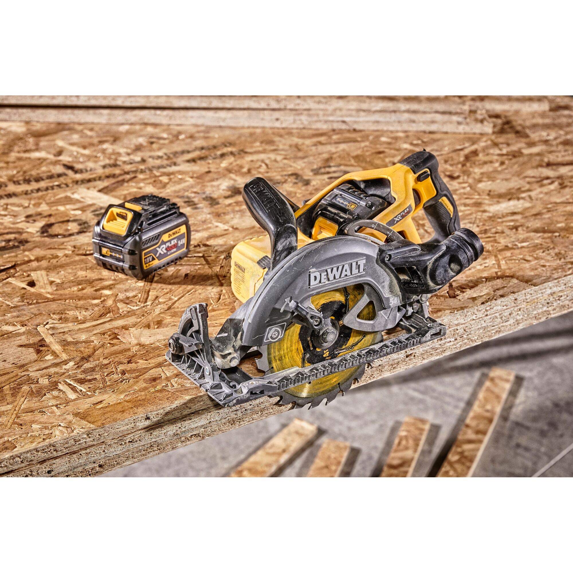 Dewalt cordless circular saw and battery on a plywood sheet in a workshop setting.