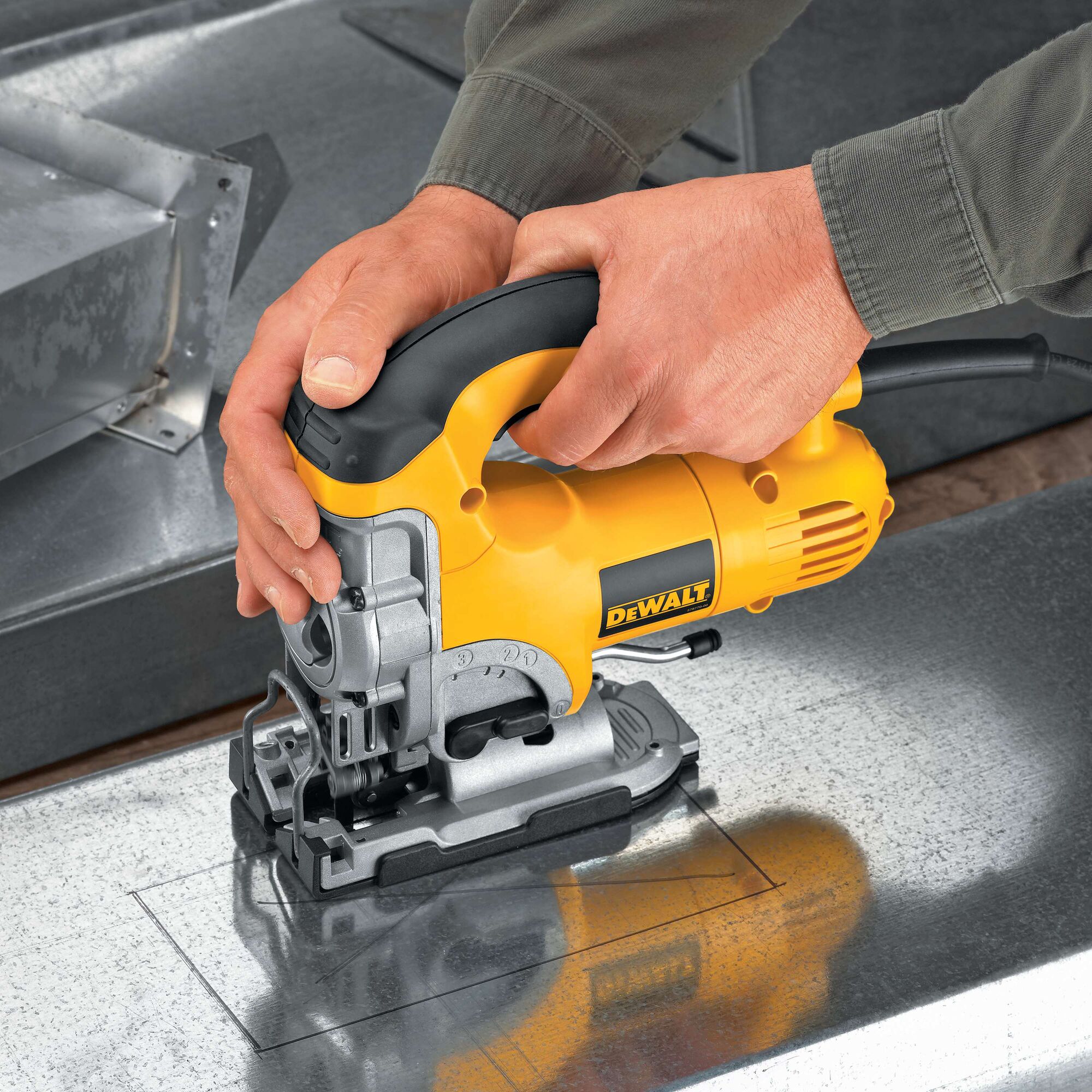 A person using a yellow and black DEWALT jigsaw to cut a square shape into a sheet of metal.