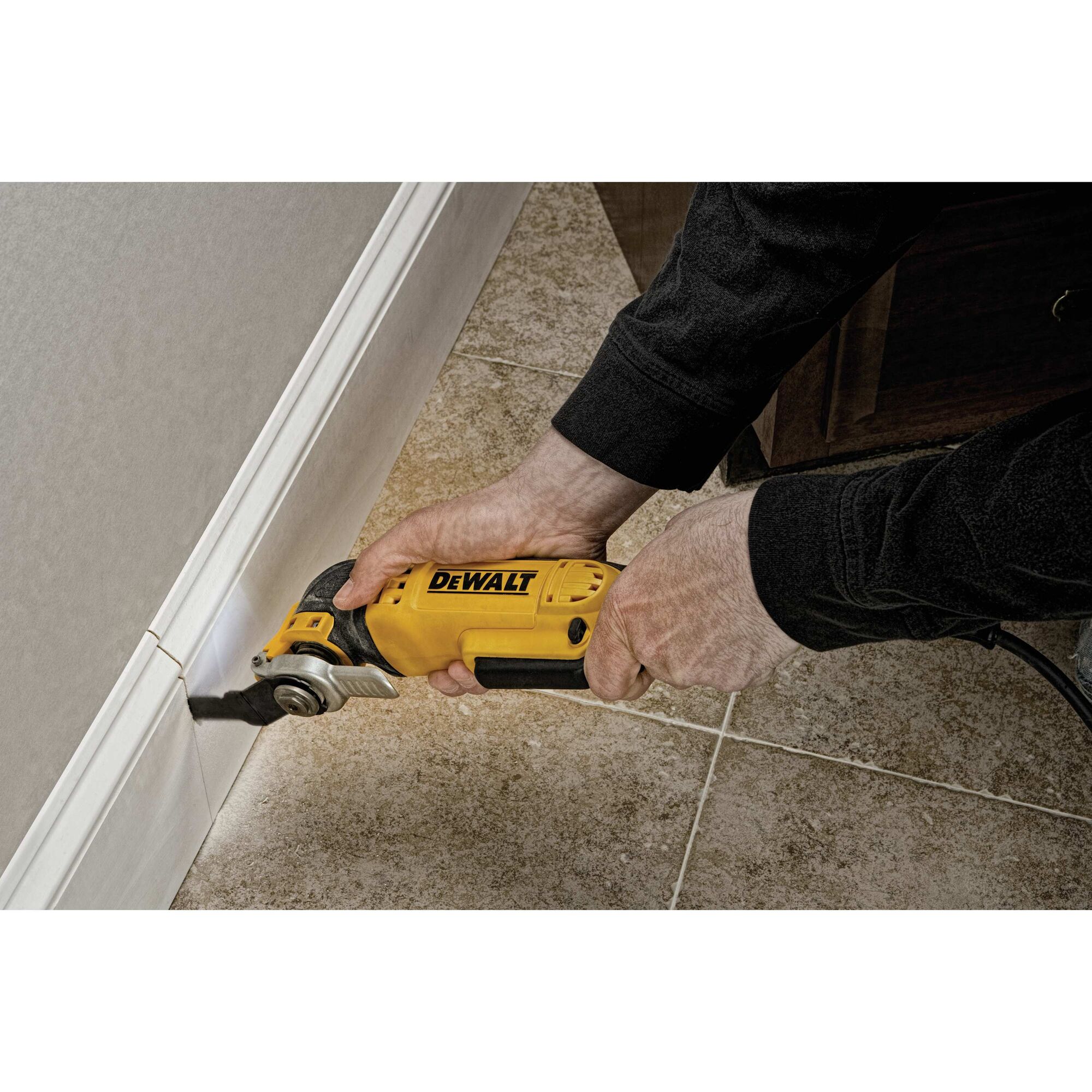 Oscillating multi tool kit being used to cut plaster.