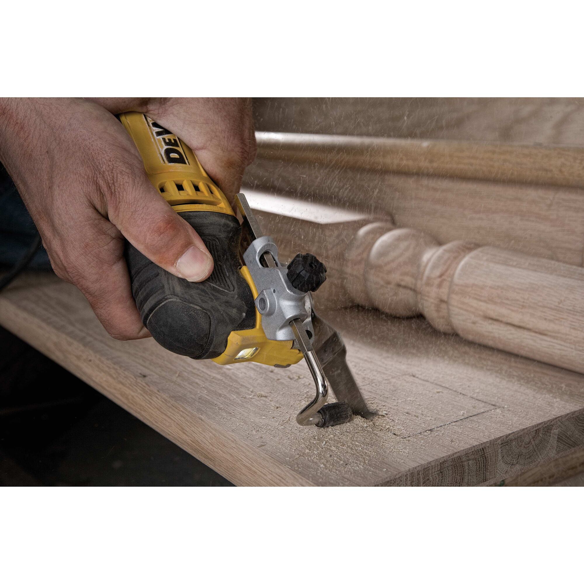 Oscillating multi tool kit being used to cut wood.