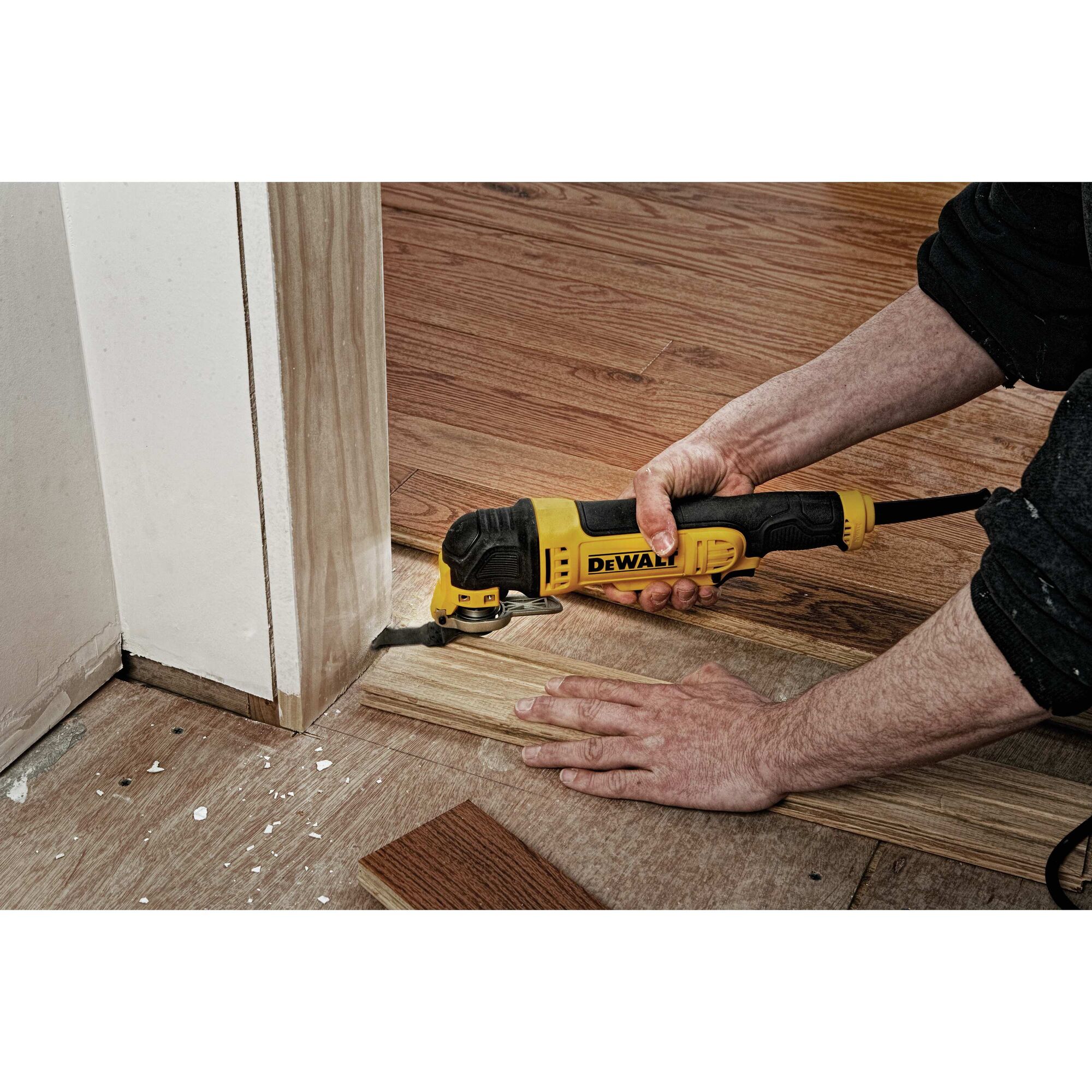 Oscillating multi tool kit being used to cut wood.