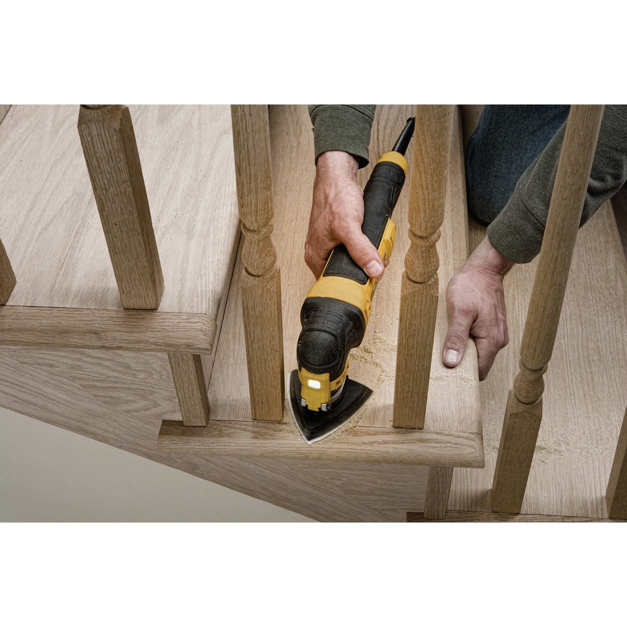 Oscillating multi tool kit being used to sand wood.