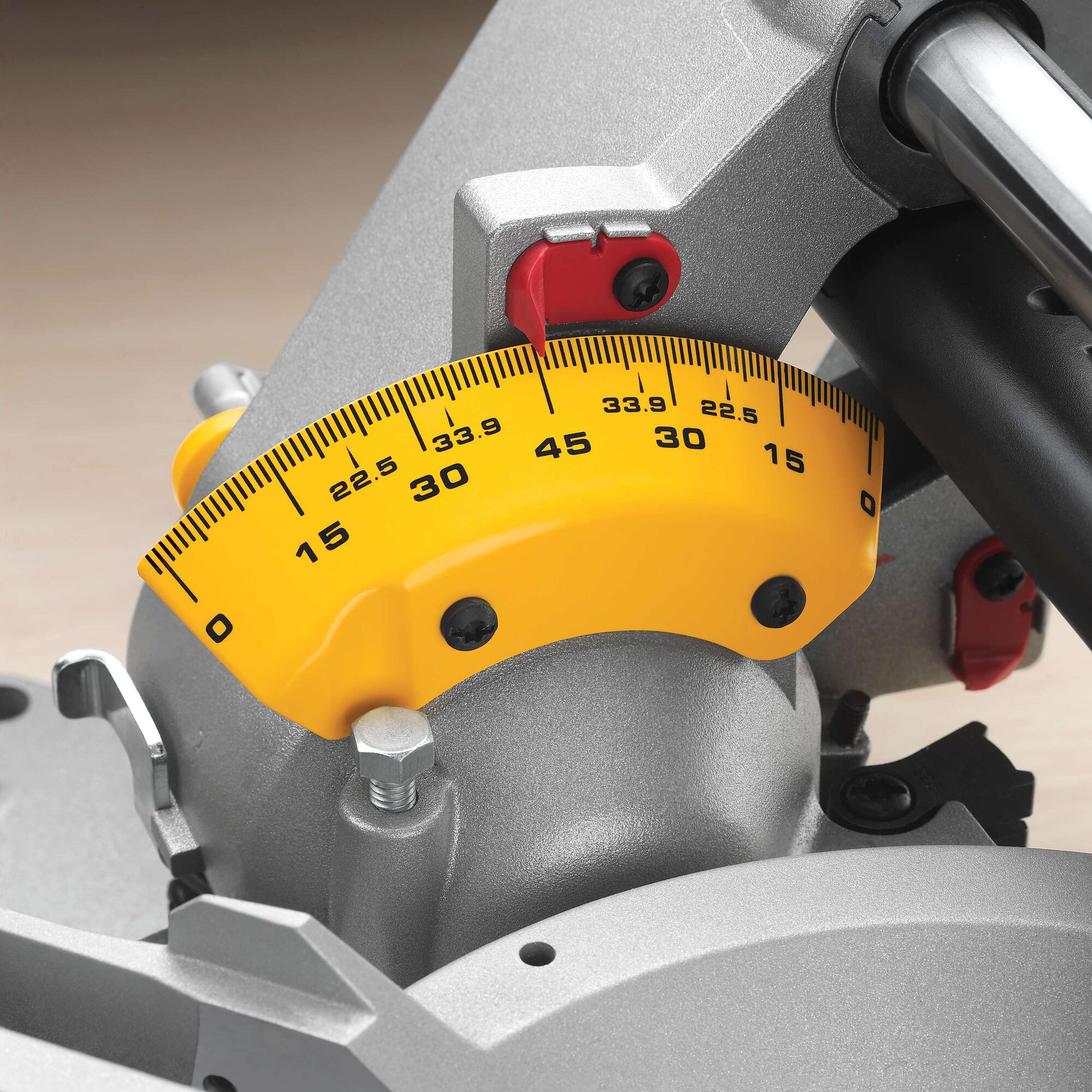 Close-up view of the yellow and silver angle adjustment scale on a DEWALT miter saw, showing measurement markings from 0 to 45 degrees.