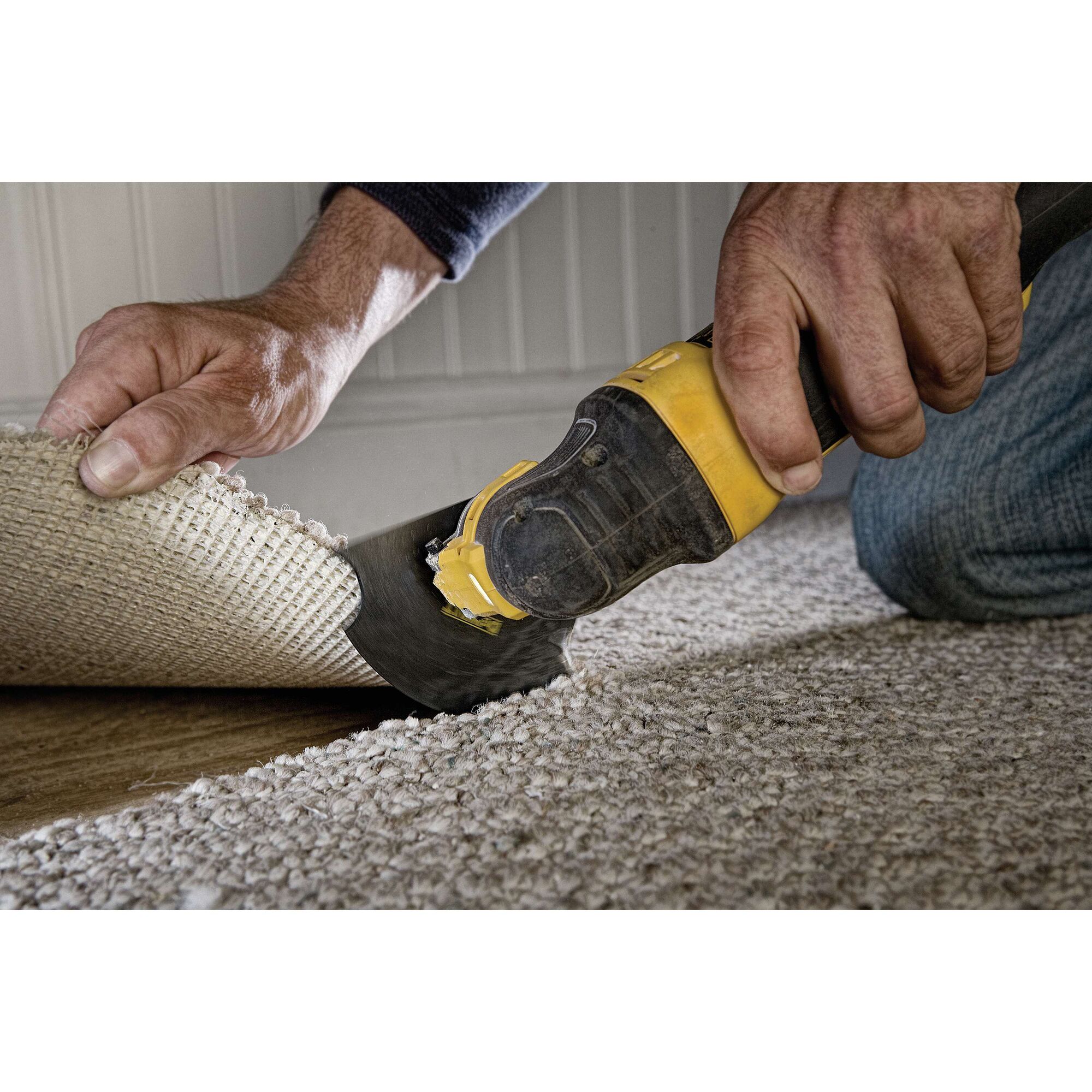 Oscillating multi tool kit being used to cut carpet.