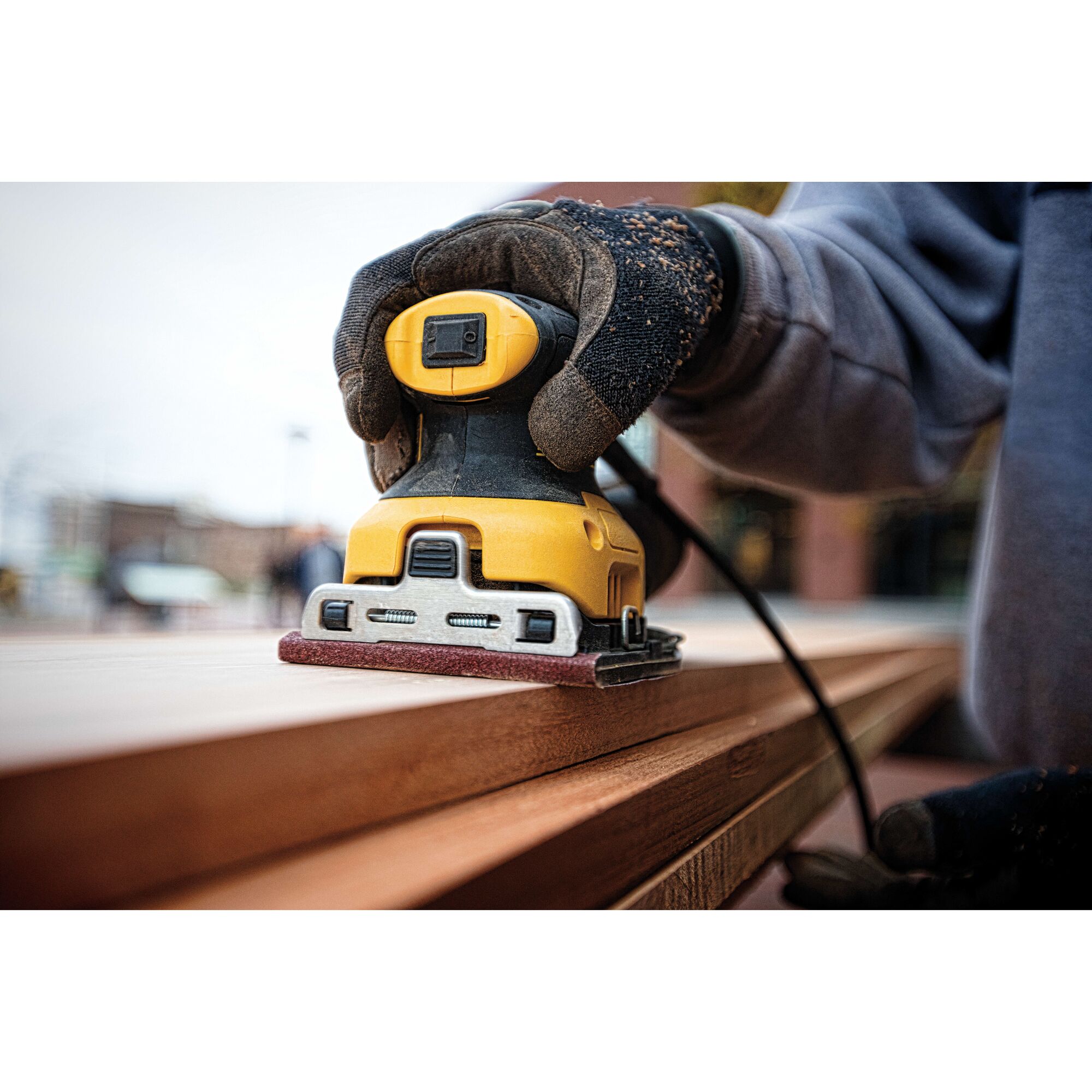 One quarter inch sheet palm grip sander sanding a wooden sheet.